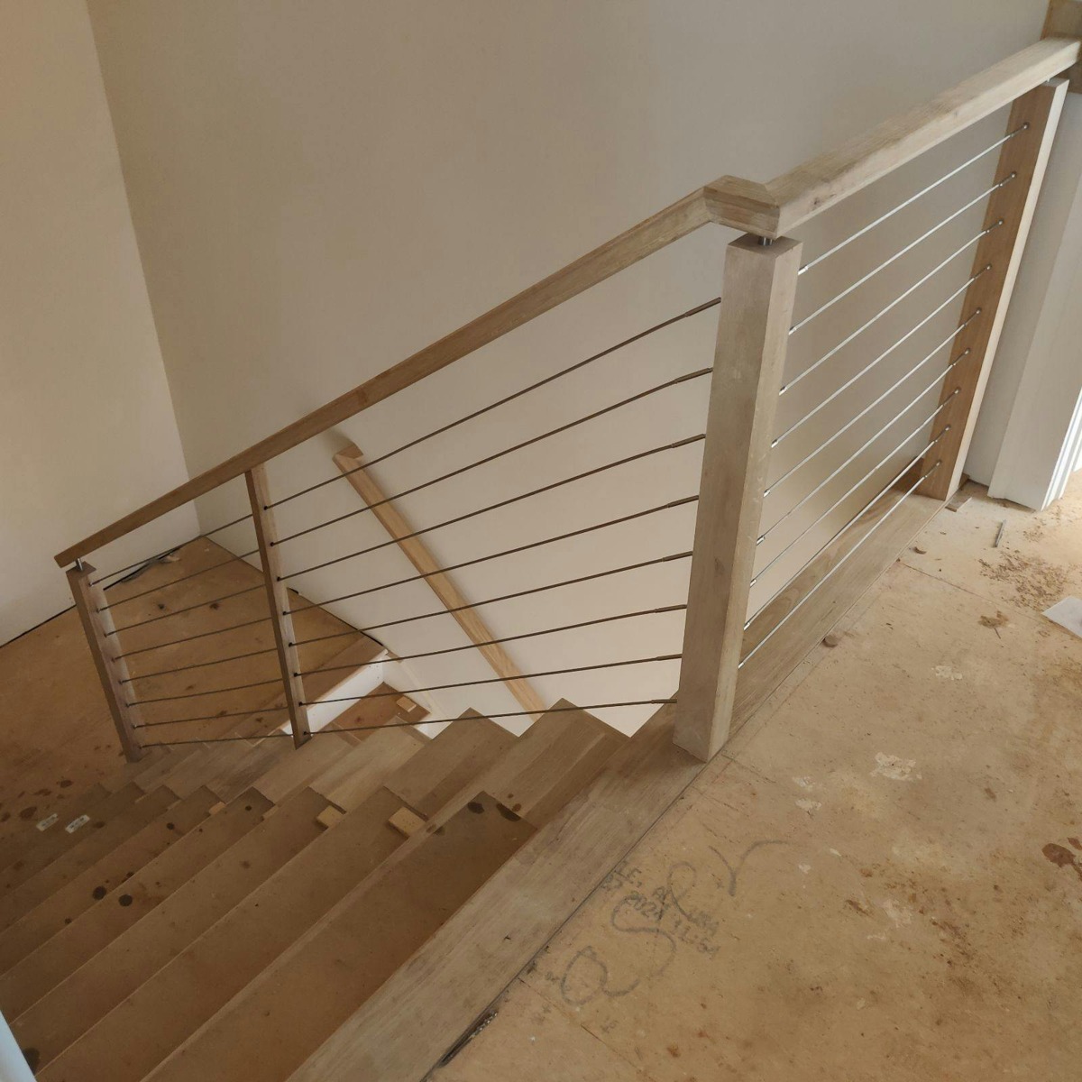 Straight staircase with horizontal metal infill between railing posts