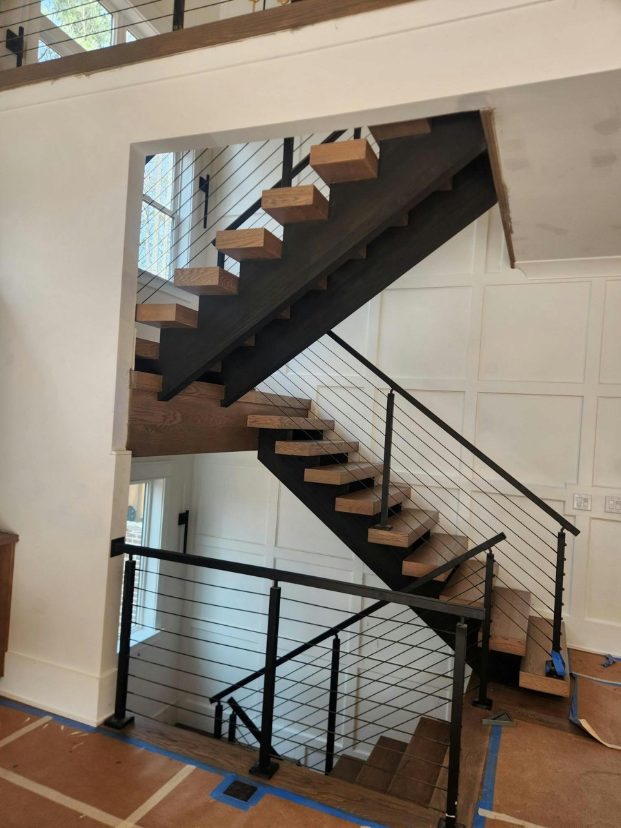 Open staircase with dark metal railing and horizontal infill